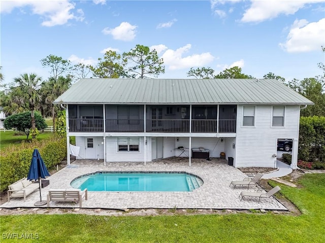 2920 24th Ave SE, Naples, FL 34117 - rear view of property with an outdoor pool, metal roof, a sunroom, and a patio
