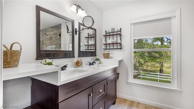 2920 24th Ave SE, Naples, FL 34117 - full bathroom featuring double vanity, wood finished floors, tiled shower, and a sink