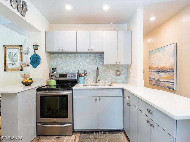 1055 8th Ave N, Naples, FL 34102 - kitchen with a peninsula, light countertops, electric stove, and a sink