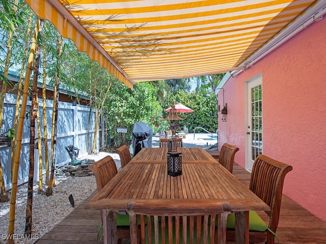 1055 8th Ave N, Naples, FL 34102 - view of patio with grilling area, a wooden deck, fence, and outdoor dining space