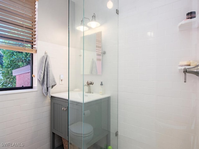 1055 8th Ave N, Naples, FL 34102 - bathroom with tile walls, an enclosed shower, vanity, and plenty of natural light