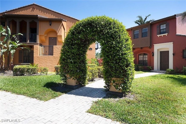 9134 Chula Vista St Unit 125, Naples, FL 34113 - mediterranean / spanish house with a front lawn and stucco siding