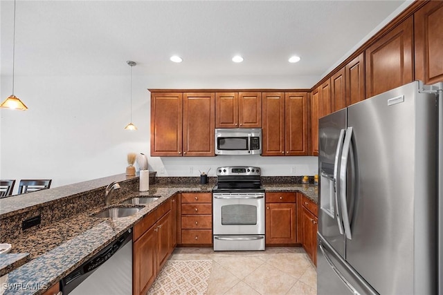 9134 Chula Vista St Unit 125, Naples, FL 34113 - kitchen with dark stone countertops, light tile patterned floors, brown cabinets, appliances with stainless steel finishes, and a sink
