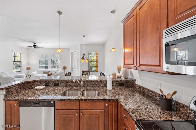 9134 Chula Vista St Unit 125, Naples, FL 34113 - kitchen featuring dark stone countertops, a sink, open floor plan, appliances with stainless steel finishes, and a peninsula