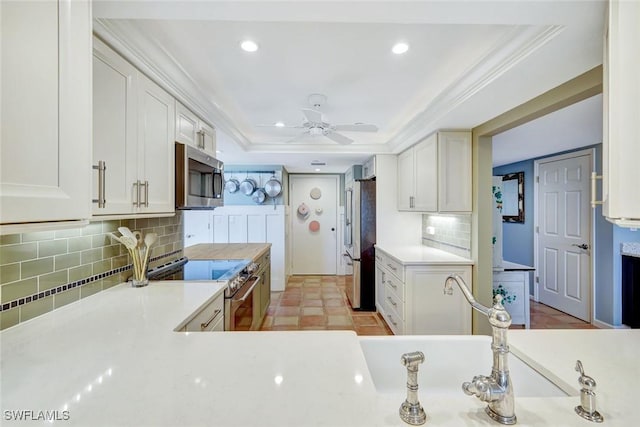 3100 Gulf Shore Blvd N Unit 103, Naples, FL 34103 - kitchen with stainless steel appliances, white cabinetry, light countertops, recessed lighting, and ornamental molding