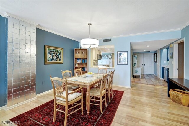 3100 Gulf Shore Blvd N Unit 103, Naples, FL 34103 - dining area featuring light wood-type flooring, ornamental molding, baseboards, and a fireplace