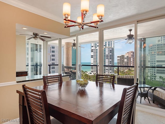 dining room featuring a city view, crown molding, and ceiling fan with notable chandelier