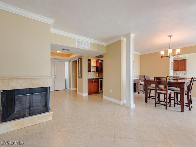 living room with an inviting chandelier, crown molding, beverage cooler, and visible vents