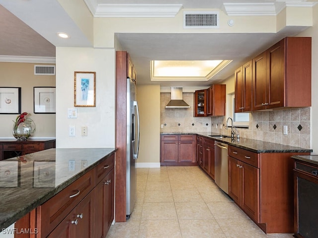 kitchen with stainless steel appliances, visible vents, a sink, and wall chimney range hood