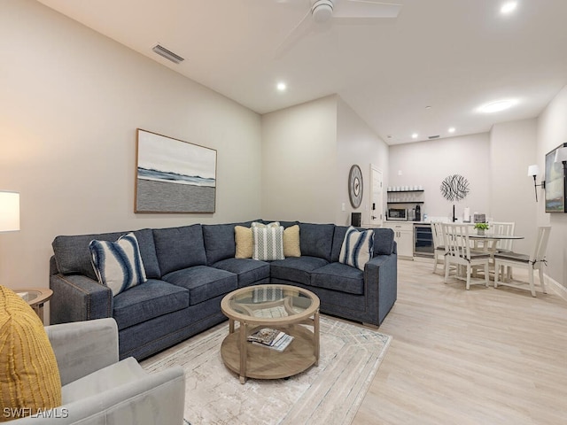 living area with light wood-style flooring, visible vents, recessed lighting, a ceiling fan, and beverage cooler