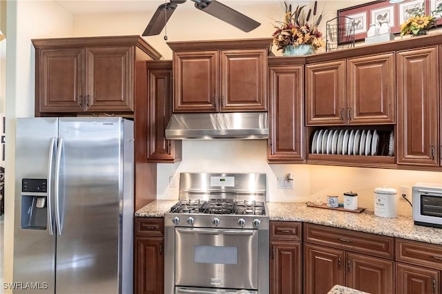 kitchen with light stone counters, a ceiling fan, appliances with stainless steel finishes, and under cabinet range hood