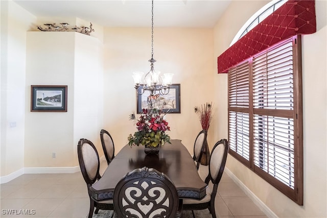 dining room with an inviting chandelier, tile patterned floors, and baseboards