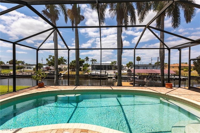 pool featuring a water view, a patio area, and a lanai