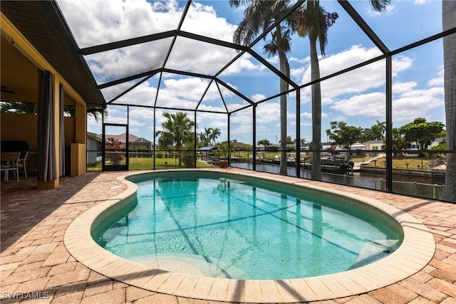 outdoor pool with a lanai, a water view, and a patio