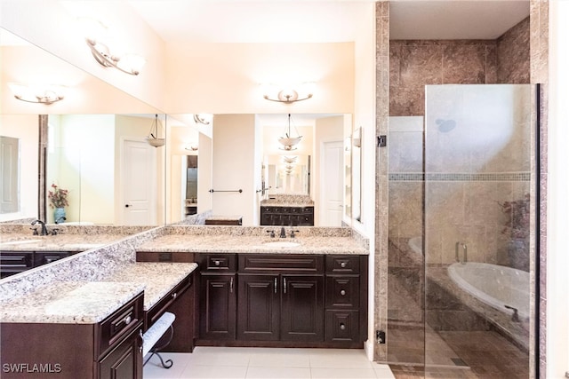 bathroom with two vanities, tiled shower, tile patterned flooring, and a sink
