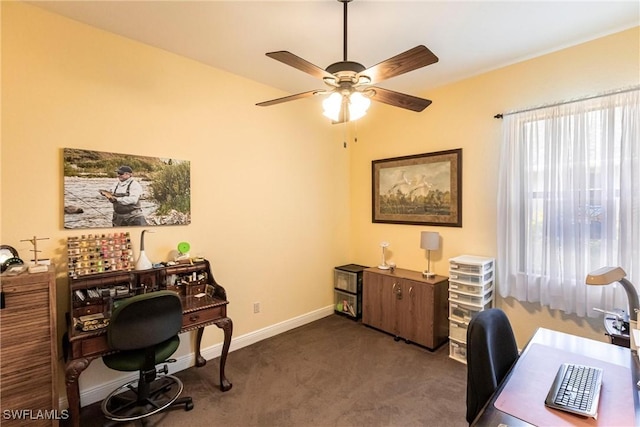 carpeted office space featuring baseboards and ceiling fan