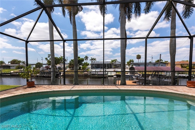 outdoor pool with a lanai and a water view