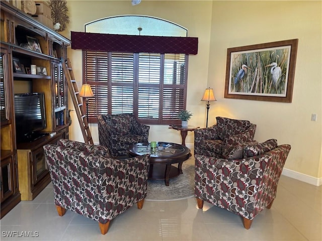 living area with baseboards and tile patterned flooring