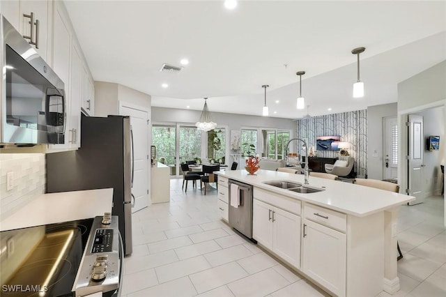 190 Indies Dr E Unit 102, Naples, FL 34114 - kitchen with visible vents, white cabinets, a sink, light countertops, and appliances with stainless steel finishes