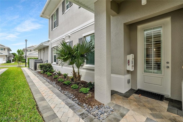 190 Indies Dr E Unit 102, Naples, FL 34114 - view of exterior entry with a yard and stucco siding