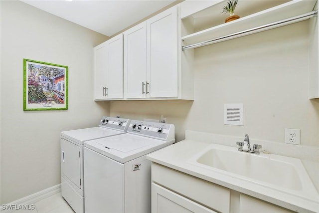 190 Indies Dr E Unit 102, Naples, FL 34114 - washroom with visible vents, a sink, washer and dryer, baseboards, and cabinet space
