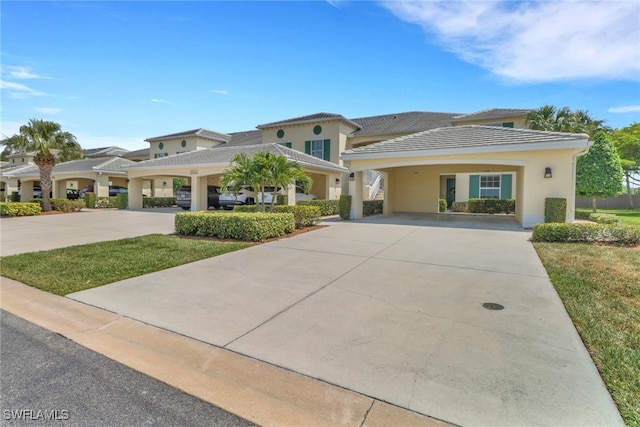 view of front of home featuring stucco siding, driveway, a carport, and a tiled roof