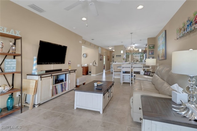 living area with light tile patterned floors, recessed lighting, visible vents, and ceiling fan with notable chandelier