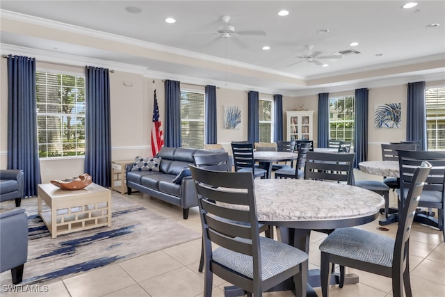 dining room featuring crown molding, light tile patterned floors, ceiling fan, a tray ceiling, and visible vents