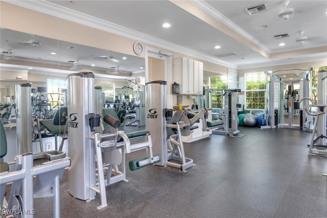 exercise room featuring visible vents, a tray ceiling, and crown molding