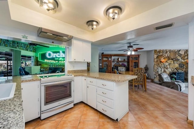 813 105th Ave N, Naples, FL 34108 - kitchen with white stove, a peninsula, light tile patterned flooring, white cabinetry, and open floor plan