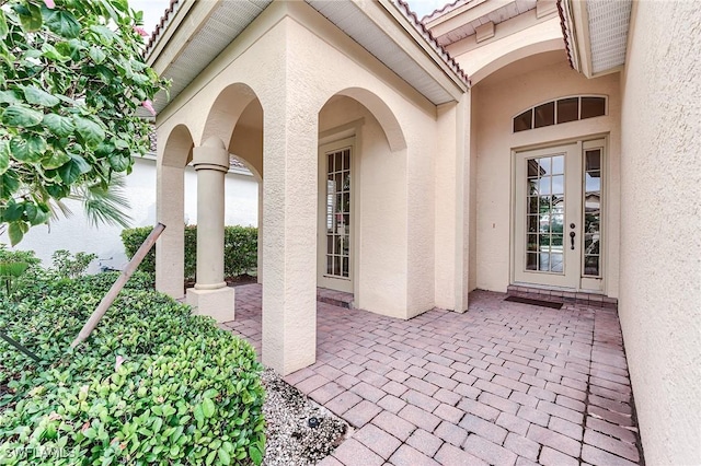 3180 Bramble Cove Ct, Fort Myers, FL 33905 - view of exterior entry with stucco siding, a tiled roof, and a patio