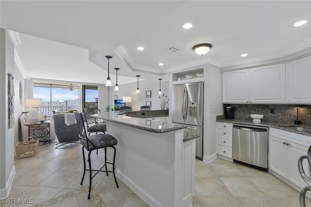 5 Bluebill Ave Unit 812, Naples, FL 34108 - kitchen with ornamental molding, dark stone countertops, appliances with stainless steel finishes, and a breakfast bar area