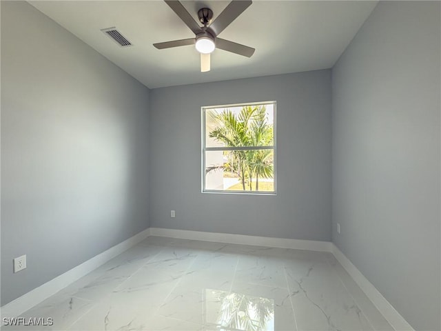 spare room featuring visible vents, marble finish floor, baseboards, and ceiling fan