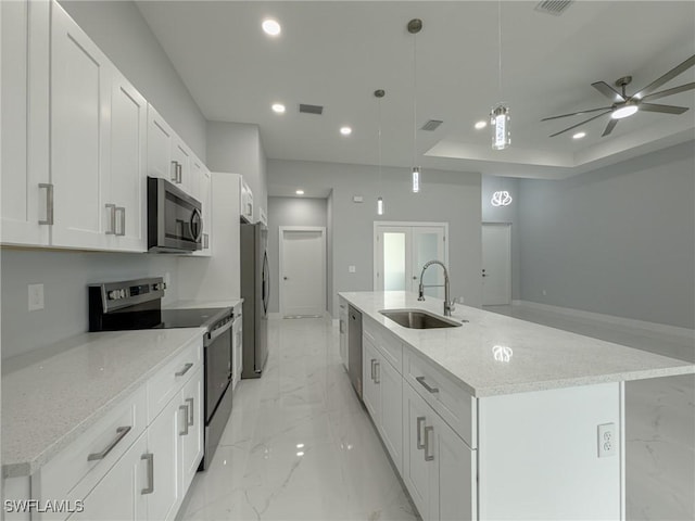 kitchen featuring white cabinets, a sink, marble finish floor, stainless steel appliances, and a spacious island