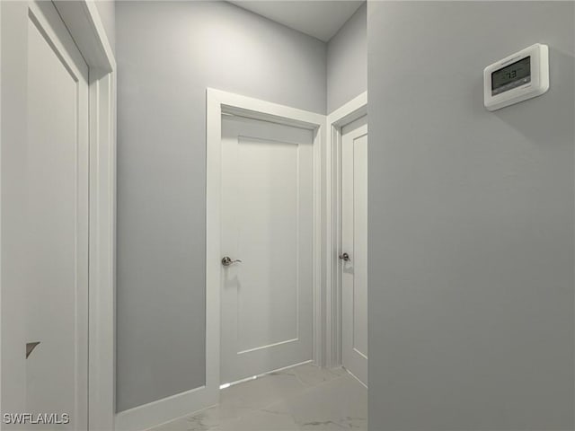 hallway featuring baseboards and marble finish floor
