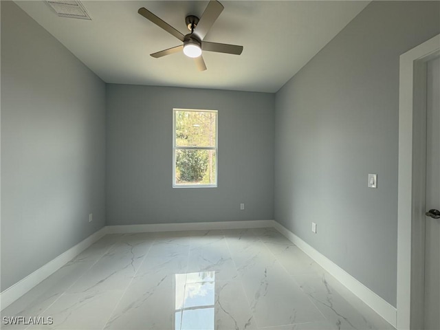 spare room featuring baseboards, a ceiling fan, marble finish floor, and visible vents