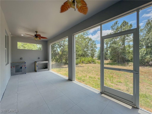 unfurnished sunroom with ceiling fan and a healthy amount of sunlight