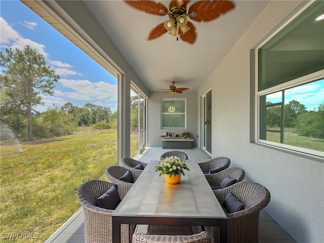 sunroom / solarium with ceiling fan and outdoor dining space