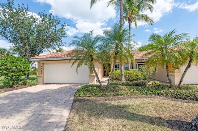14194 Fall Creek Ct, Naples, FL 34114 - mediterranean / spanish house featuring stucco siding, a tile roof, and a garage