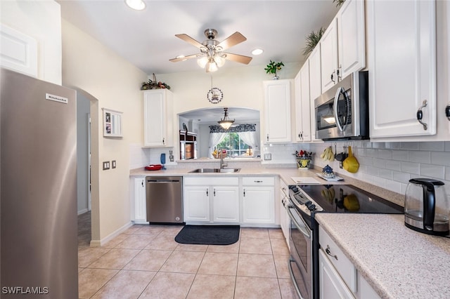 14194 Fall Creek Ct, Naples, FL 34114 - kitchen featuring appliances with stainless steel finishes, a sink, decorative backsplash, light countertops, and a ceiling fan
