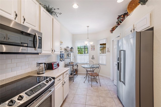 14194 Fall Creek Ct, Naples, FL 34114 - kitchen with appliances with stainless steel finishes, light countertops, white cabinets, backsplash, and pendant lighting