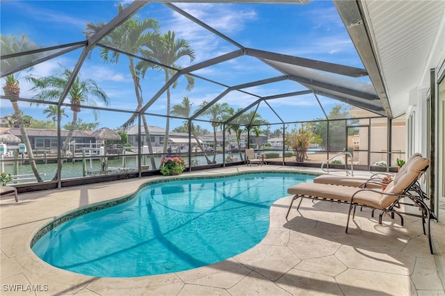 outdoor pool with a lanai, a water view, and a patio area