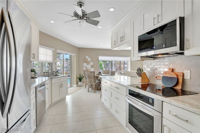 kitchen with white cabinets, appliances with stainless steel finishes, and decorative backsplash