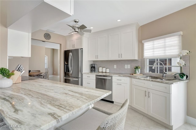 kitchen with white cabinetry, a ceiling fan, appliances with stainless steel finishes, and a sink