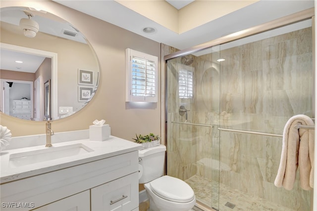 bathroom with toilet, visible vents, a shower stall, and vanity