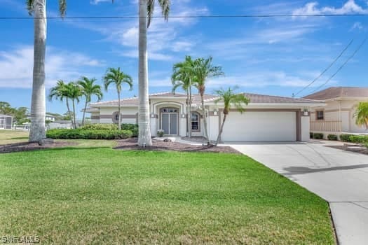 view of front of property with an attached garage, concrete driveway, and a front lawn