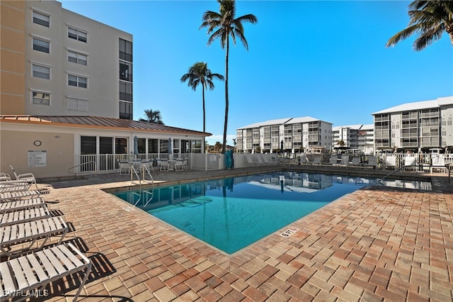 pool featuring fence and a patio area