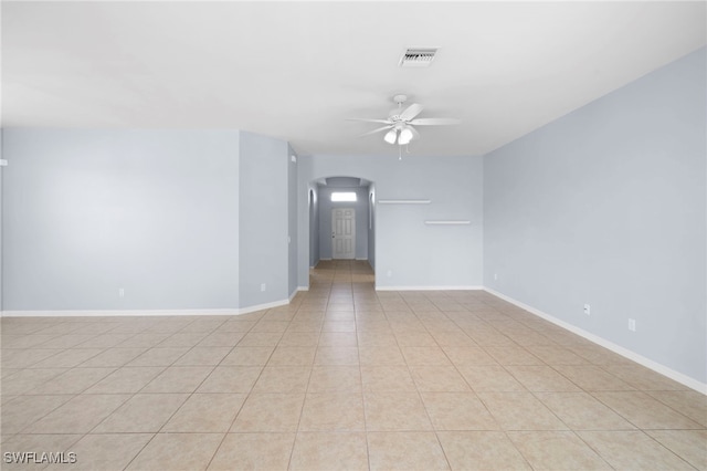 1322 SW 22nd Ave, Cape Coral, FL 33991 - spare room featuring arched walkways, light tile patterned flooring, baseboards, visible vents, and ceiling fan