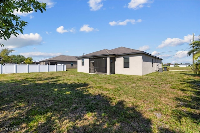 1322 SW 22nd Ave, Cape Coral, FL 33991 - back of house featuring fence, a sunroom, a yard, and stucco siding