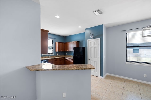 1322 SW 22nd Ave, Cape Coral, FL 33991 - kitchen with a peninsula, stone counters, visible vents, freestanding refrigerator, and baseboards